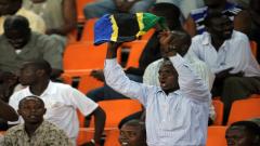 A Tanzanian sports fan raises the flag